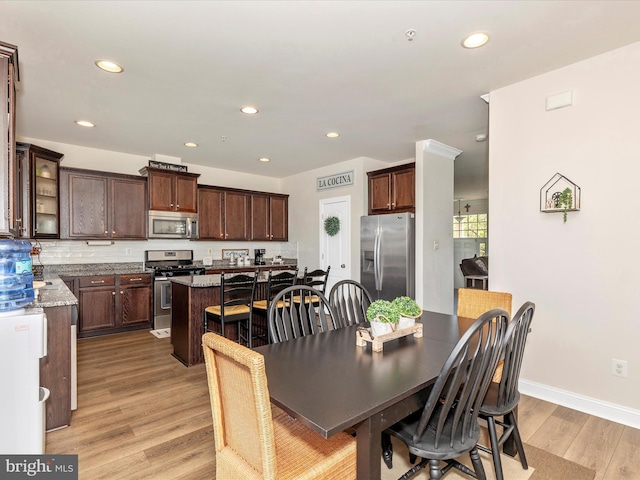dining room with recessed lighting, light wood-style flooring, and baseboards