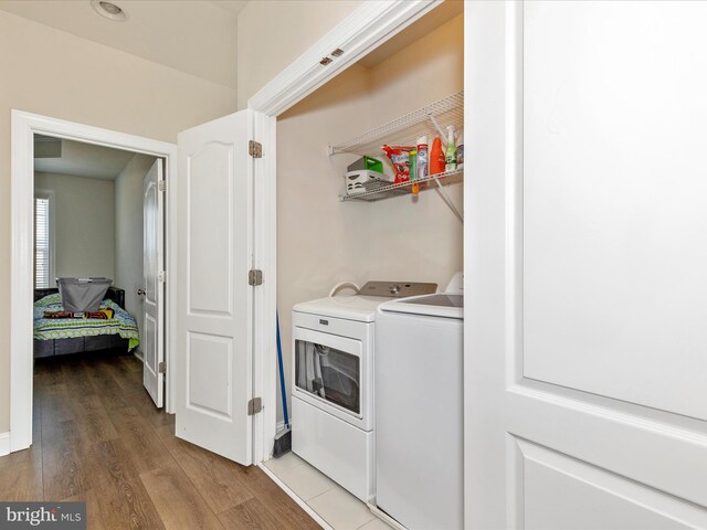 laundry area featuring independent washer and dryer, wood finished floors, and laundry area