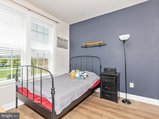 bedroom with baseboards and wood finished floors