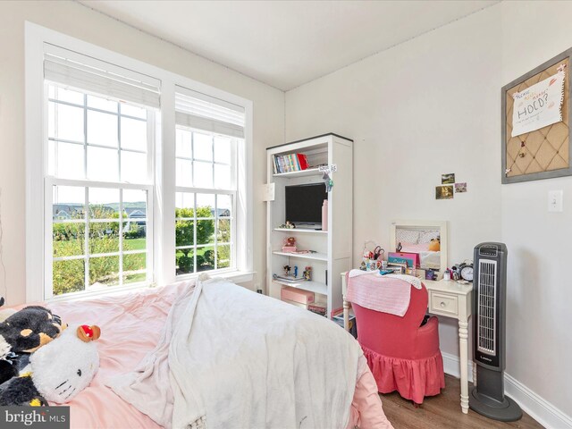 bedroom with wood finished floors and baseboards