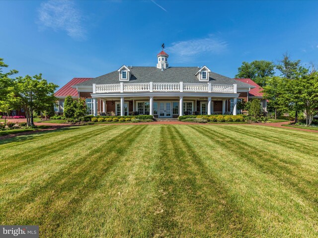 rear view of property featuring a lawn and french doors