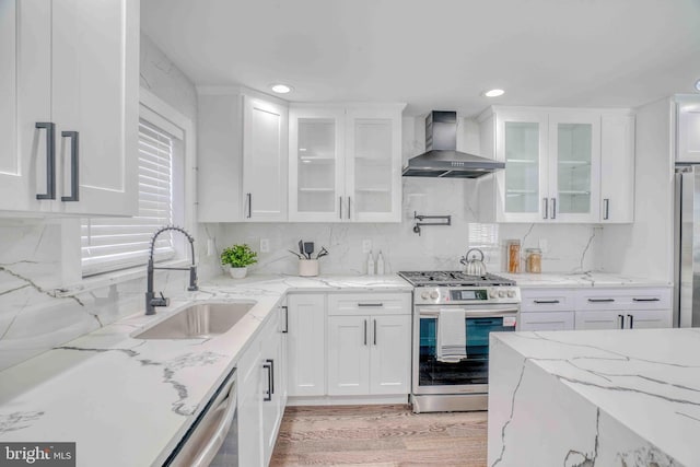 2832 Edgemont St, Philadelphia, PA 19134 - kitchen featuring white cabinets, a sink, tasteful backsplash, wall chimney range hood, and appliances with stainless steel finishes