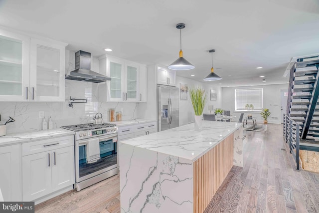 2832 Edgemont St, Philadelphia, PA 19134 - kitchen with white cabinets, light wood-type flooring, wall chimney exhaust hood, and appliances with stainless steel finishes