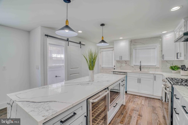 2832 Edgemont St, Philadelphia, PA 19134 - kitchen with a barn door, a sink, light wood-style floors, appliances with stainless steel finishes, and wine cooler