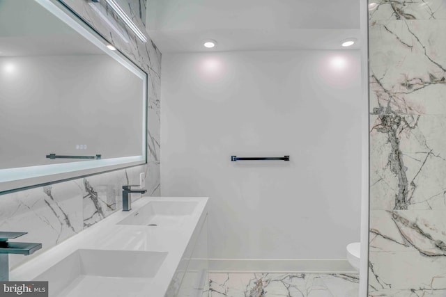 2832 Edgemont St, Philadelphia, PA 19134 - full bath featuring marble finish floor, double vanity, toilet, a sink, and baseboards