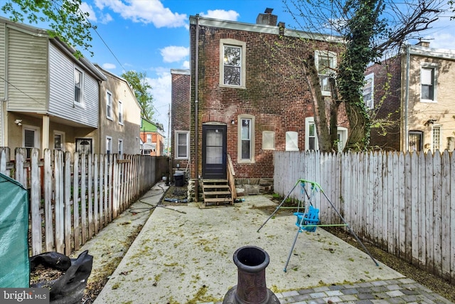 149 E Meehan Ave, Philadelphia, PA 19119 - rear view of house featuring entry steps, a chimney, brick siding, and a fenced backyard