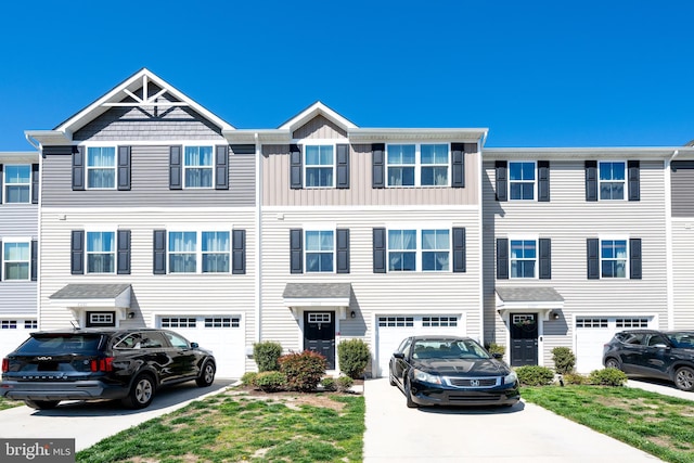 multi unit property with a garage, driveway, and board and batten siding