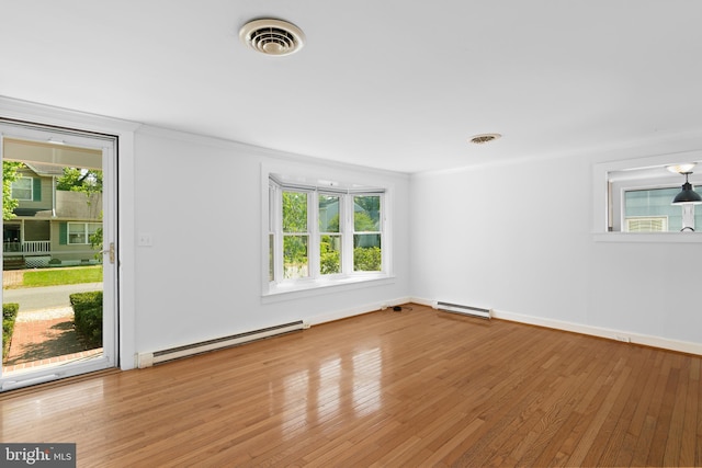 103 W Marengo, Saint Michaels, MD 21663 - spare room featuring a baseboard radiator, a wealth of natural light, visible vents, and wood finished floors