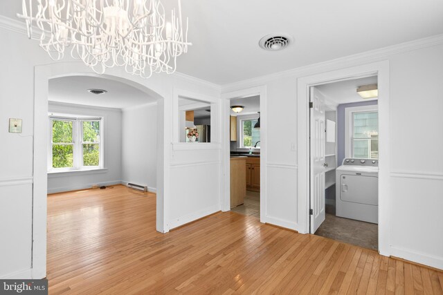 103 W Marengo, Saint Michaels, MD 21663 - unfurnished dining area with light wood finished floors, visible vents, arched walkways, washer / dryer, and ornamental molding
