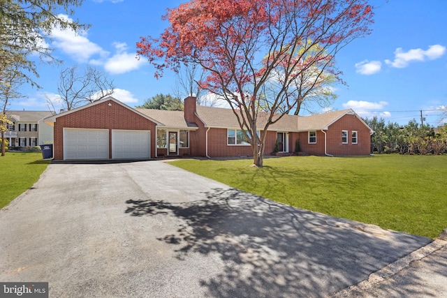 single story home with a garage, driveway, a front lawn, and brick siding