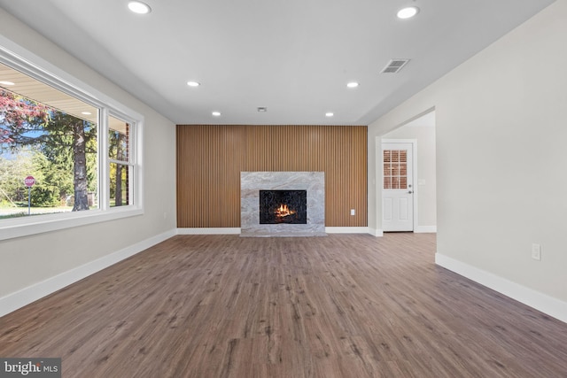 unfurnished living room with visible vents, recessed lighting, baseboards, and a fireplace