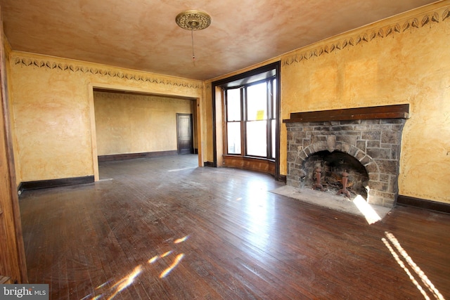 unfurnished living room with hardwood / wood-style flooring, baseboards, a fireplace, and ornamental molding