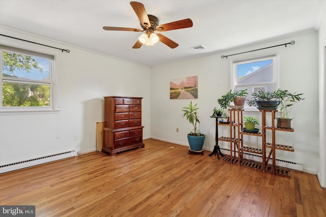 sitting room featuring a wealth of natural light, ornamental molding, light wood-style flooring, and visible vents