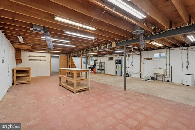 below grade area with a sink, tile patterned floors, hybrid water heater, and stairs