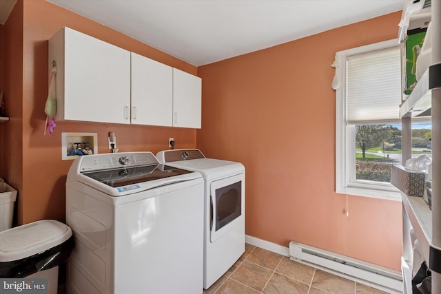 clothes washing area featuring baseboards, a baseboard heating unit, cabinet space, and washer and clothes dryer