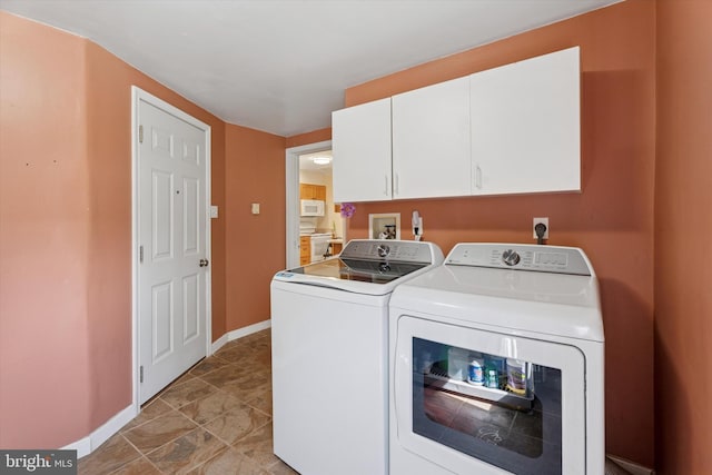 laundry room with separate washer and dryer, baseboards, and cabinet space