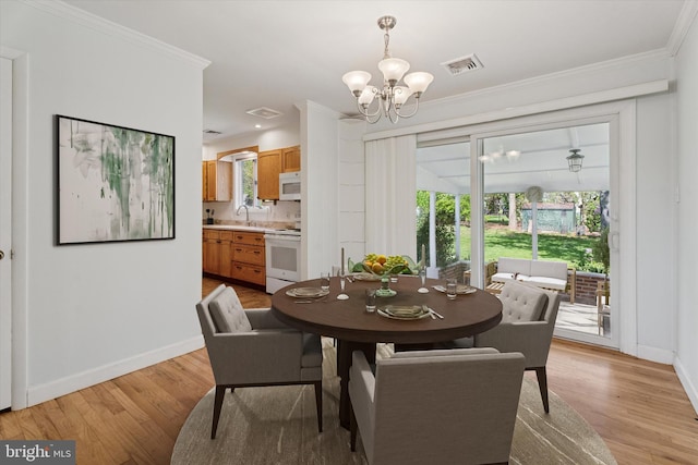 dining room with baseboards, light wood-style flooring, a chandelier, and visible vents