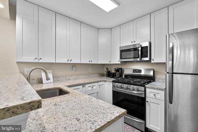kitchen featuring white cabinets, stainless steel appliances, and a sink