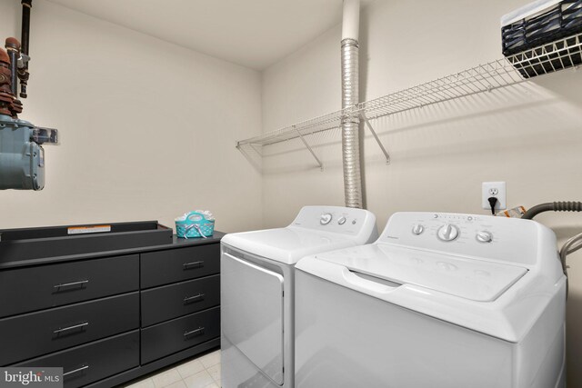 washroom with laundry area, light tile patterned floors, and separate washer and dryer