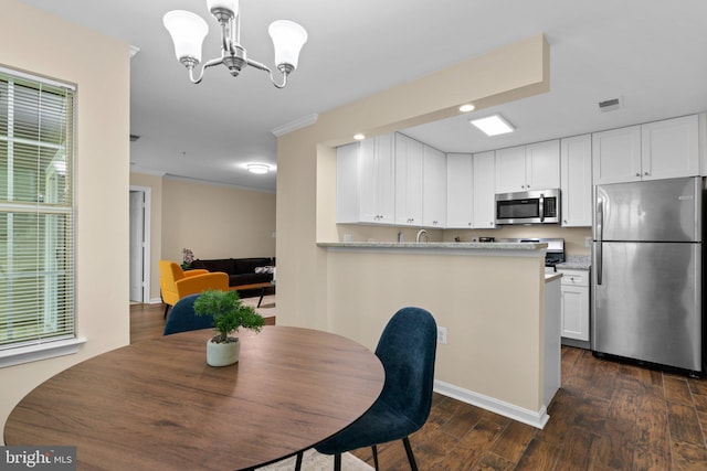 dining space featuring visible vents, dark wood finished floors, an inviting chandelier, ornamental molding, and recessed lighting