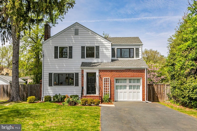traditional home with aphalt driveway, fence, a chimney, brick siding, and a shingled roof