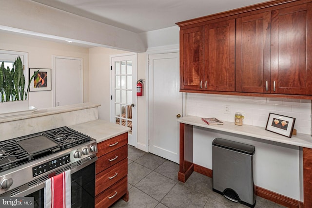kitchen with light countertops, baseboards, tasteful backsplash, and gas range