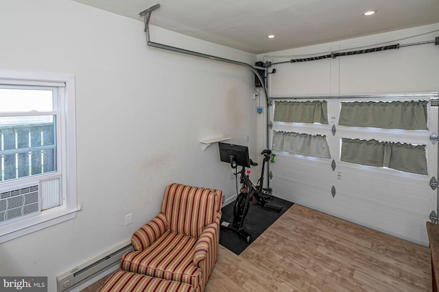 exercise area with recessed lighting, baseboard heating, and wood finished floors