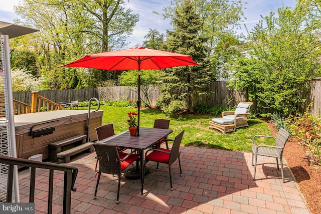 view of patio with a hot tub, a fenced backyard, and outdoor dining space