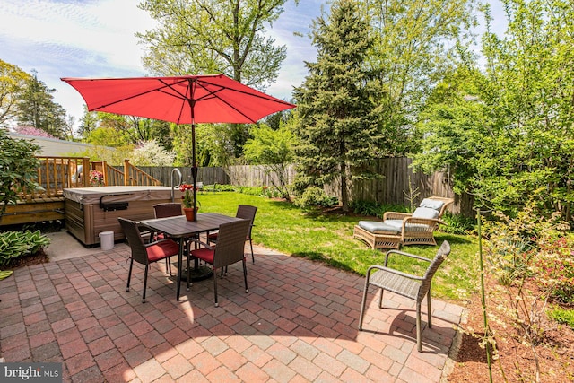 view of patio featuring a fenced backyard, a hot tub, and outdoor dining space