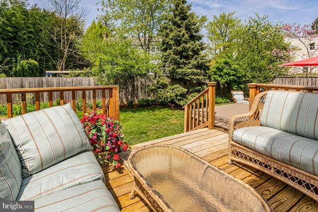 wooden terrace with a fenced backyard, an outdoor living space, and a yard