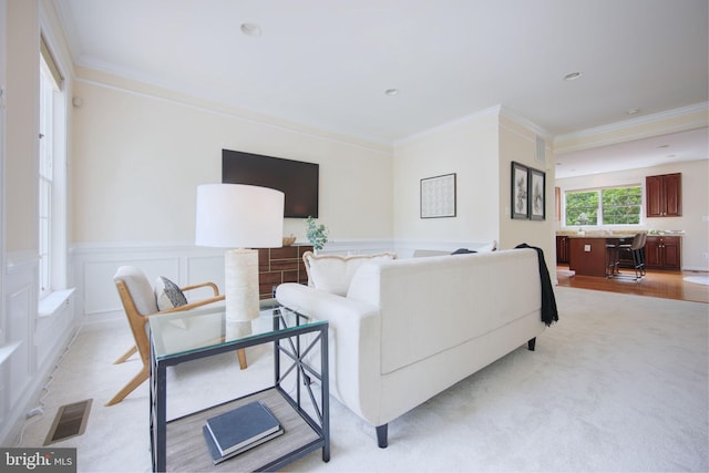 15648 Avocet Loop, Woodbridge, VA 22191 - living room featuring wainscoting, visible vents, ornamental molding, and light carpet