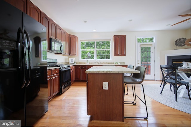 15648 Avocet Loop, Woodbridge, VA 22191 - kitchen with a kitchen island, a kitchen breakfast bar, plenty of natural light, and black appliances