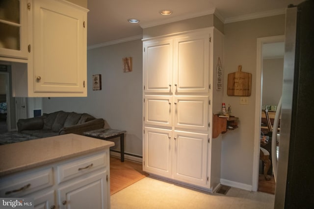 kitchen featuring white cabinetry and baseboard heating