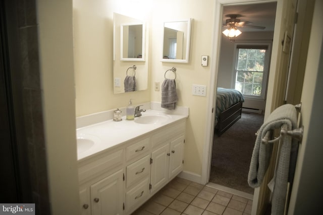 bathroom featuring double vanity, ceiling fan, baseboard heating, a sink, and tile patterned floors