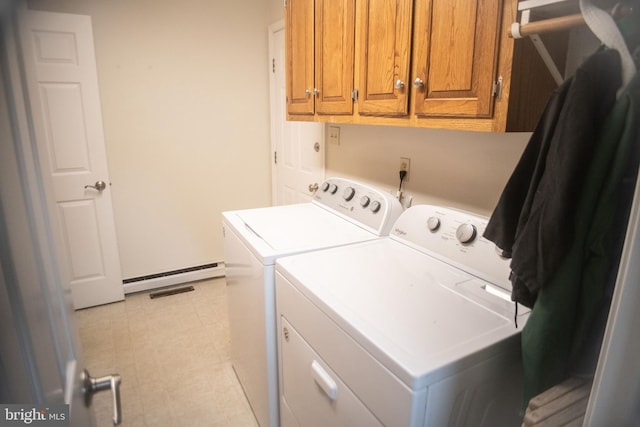 clothes washing area with a baseboard heating unit, cabinet space, and washer and clothes dryer