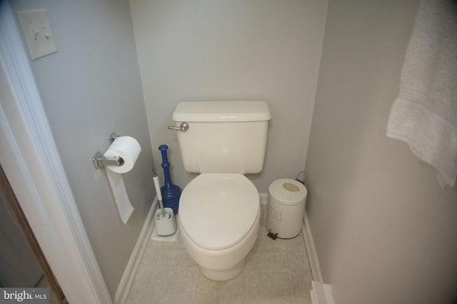 bathroom with tile patterned flooring, baseboards, and toilet