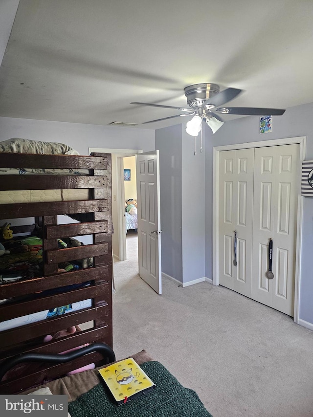 unfurnished bedroom with a ceiling fan, baseboards, carpet, and a closet