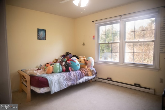 carpeted bedroom with multiple windows, baseboard heating, and a ceiling fan