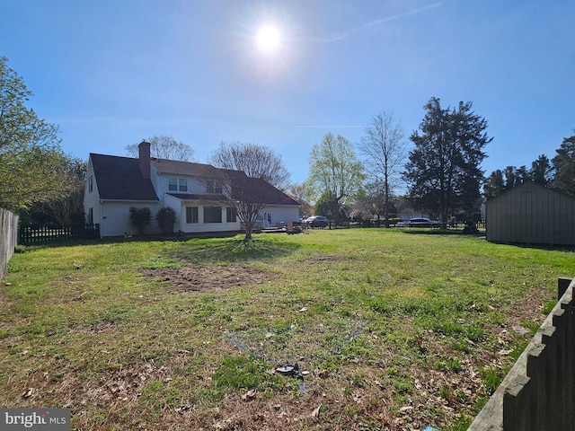 view of yard with an outdoor structure, fence, and a shed