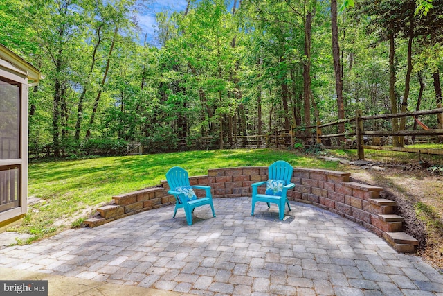 view of patio / terrace with a wooded view and a fenced backyard