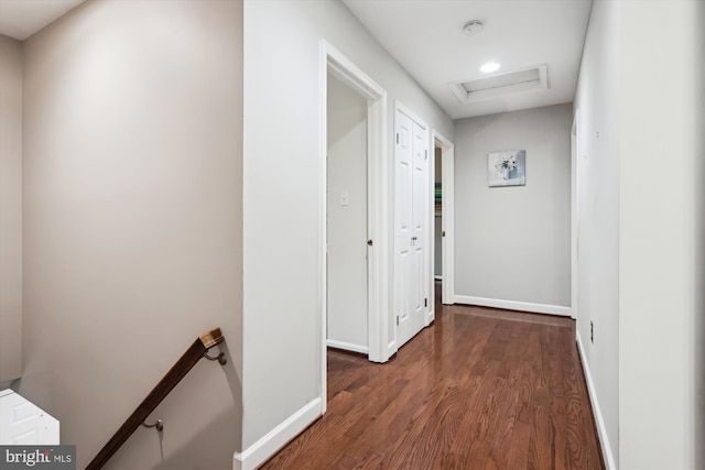 hallway with baseboards, attic access, wood finished floors, and an upstairs landing