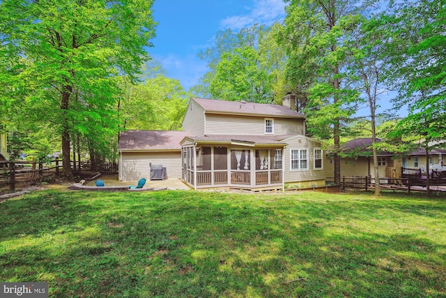 back of house with a sunroom, fence, a yard, and a chimney