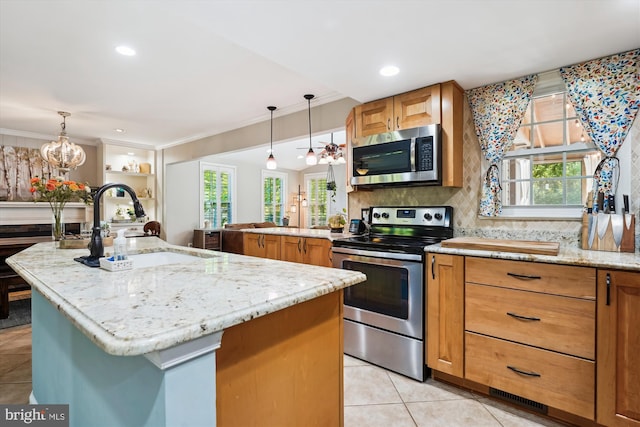 kitchen featuring a sink, appliances with stainless steel finishes, light tile patterned floors, and light stone countertops