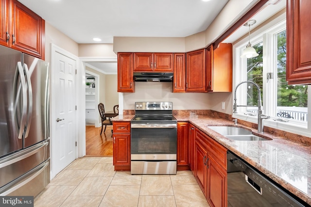 kitchen with plenty of natural light, appliances with stainless steel finishes, under cabinet range hood, and a sink