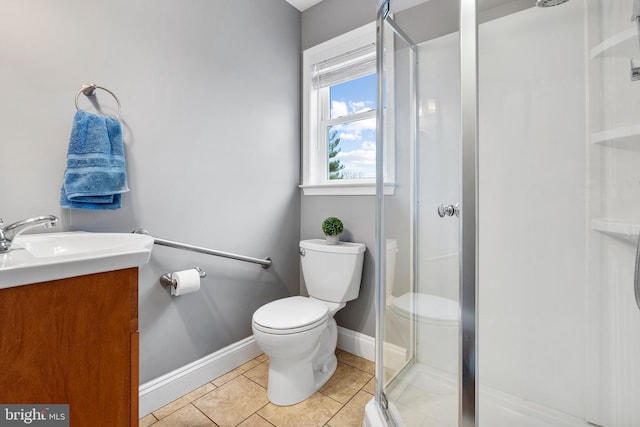 bathroom with toilet, tile patterned floors, a stall shower, vanity, and baseboards