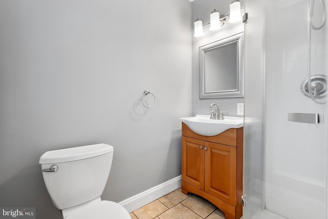 bathroom with tile patterned floors, baseboards, vanity, and toilet