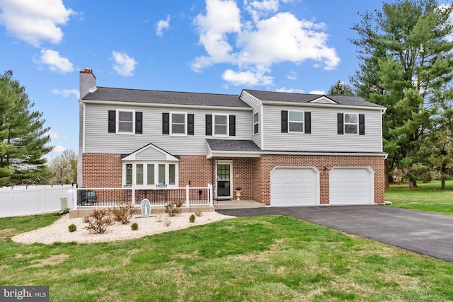 view of front of house with driveway, fence, a front yard, a garage, and brick siding