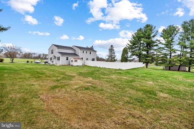 back of house featuring fence and a yard