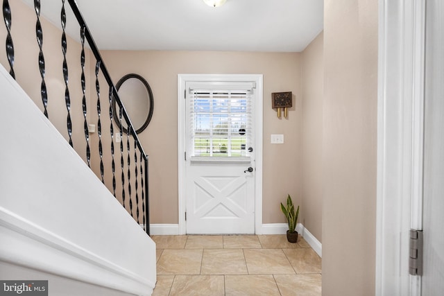 entrance foyer with stairway, baseboards, and light tile patterned floors