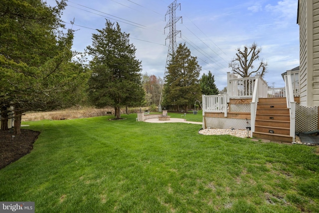 view of yard with a fire pit, a wooden deck, and stairs